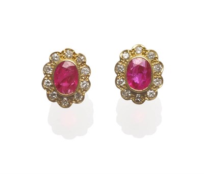 Lot 659 - A Pair of Ruby and Diamond Cluster Stud Earrings, the oval cut rubies in a rubbed over setting...