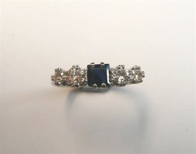 Lot 664 - A Sapphire and Diamond Five Stone Ring, a step cut sapphire within a pair of graduated round...