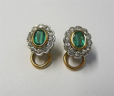 Lot 665 - A Pair of 18 Carat Gold Emerald and Diamond Cluster Earrings, the oval cut emerald in a yellow...