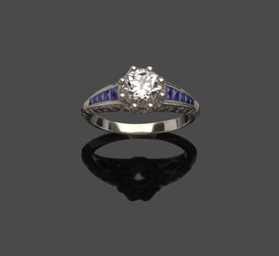 Lot 670 - A Diamond and Sapphire Ring, a round brilliant cut diamond within a diamond set crown and...