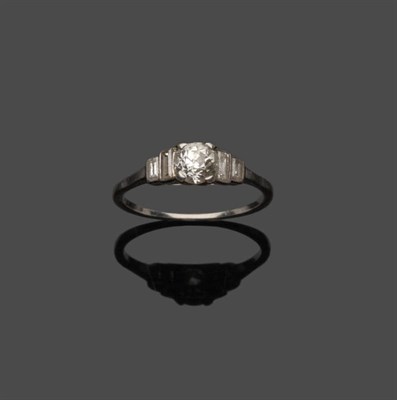 Lot 671 - An Art Deco Diamond Solitaire Ring, an old cut diamond between a pair of graduated baguette cut...