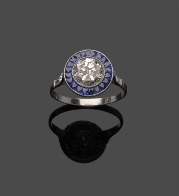 Lot 676 - A Diamond and Sapphire Cluster Ring, the round brilliant cut diamond within a calibré cut sapphire