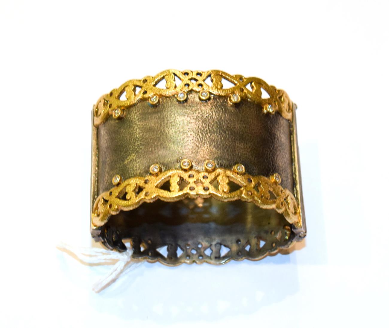 Lot 194 - A silver, gilt and diamond hinged bangle
