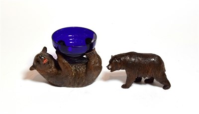 Lot 238 - A Black Forest carved bear with another supporting a blue glass dish (2)