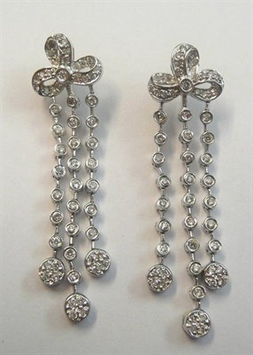 Lot 683 - A Pair of Diamond Drop Earrings, a bow motif suspends three chains of collet set diamonds, to...