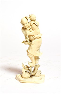 Lot 241 - A Japanese ivory Okimono of a man holding a flower, circa 1900