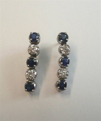 Lot 684 - A Pair of Sapphire and Diamond Drop Earrings, each drop of five stones, alternating round brilliant