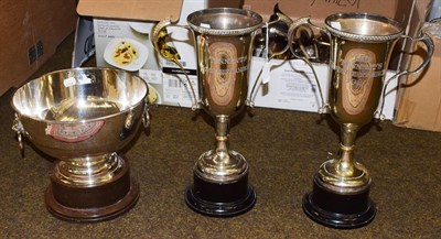 Lot 408 - Two twin handled silver plated trophy cups, and a silver plated trophy bowl with ring and lion mask