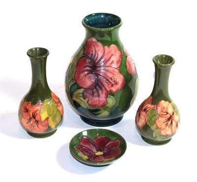 Lot 427 - Four Walter Moorcroft hibiscus vases and dish on a green ground