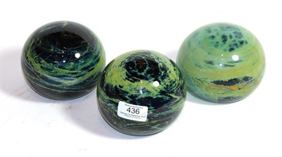 Lot 436 - Three large Mdina glass paperweights, in blue, green and yellow, two signed Mdina, 12cm diameter