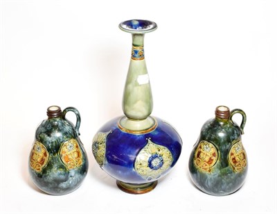 Lot 449 - A pair of Royal Doulton stoneware bottle form jugs, floral decoration, together with a bottle...