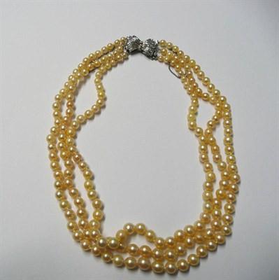 Lot 715 - A Cultured Pearl Necklace, three rows of graduated cultured pearls strung to a bow shaped clasp...