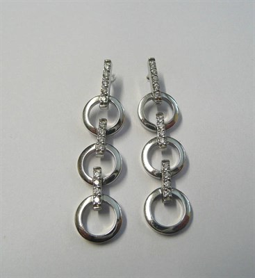 Lot 716 - A Pair of Drop Earrings, diamond set bars link plain polished white loops, total diamond weight...