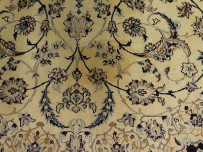 Lot 1089 - Nain part silk carpet the ivory field of scrolling vines and palmettes around a flower head...