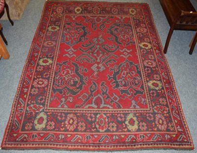 Lot 1098 - Donegal rug, the scarlet field with Ushak medallions enclosed by flower head borders, 231cm by...
