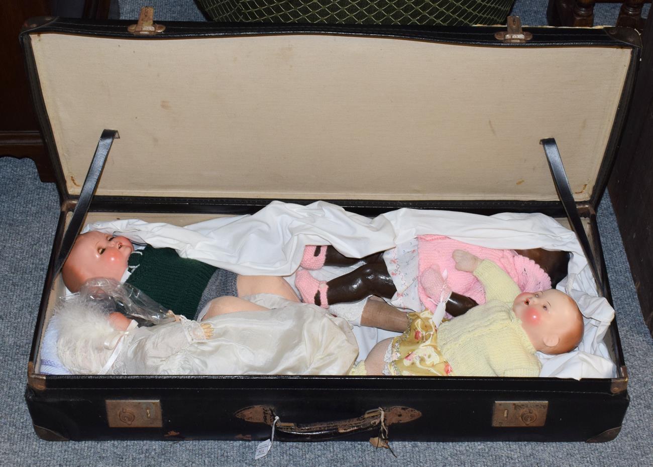 Lot 1134 - Two bisque head rocking eye dolls marked 'AM', three further dolls and a travelling case (6)