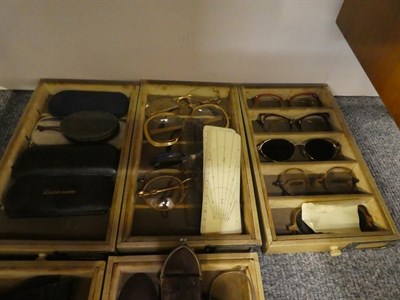 Lot 1162 - An early 20th century oak opticians desk together with collection of spectacles, lenses, two albums