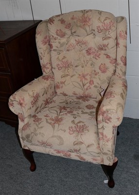 Lot 1183 - A modern wingback chair with floral upholstery