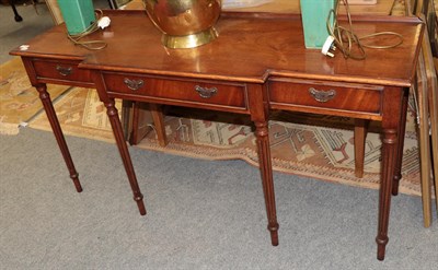 Lot 1224 - A reproduction mahogany break front hall table with three drawers and fluted legs, 152cm wide...