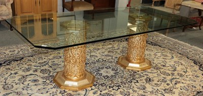 Lot 1237 - A modern rectangular glass top dining table, raised on twin Italian elaborate parcel gilt...