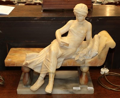 Lot 1246 - A late 19th/early 20th century alabaster figure of a lady reclining on a bench , 45.5cm high by...