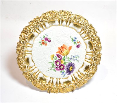 Lot 36 - A 20th century Meissen floral painted plate, moulded in relief with gilt border, 31cm diameter