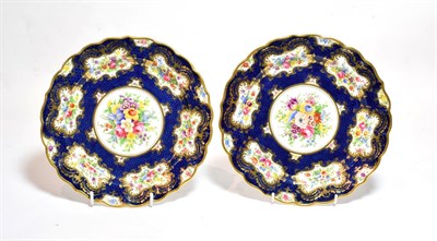 Lot 136 - A pair of Royal Worcester floral painted plates, with a blue scale ground, 23cm diameter