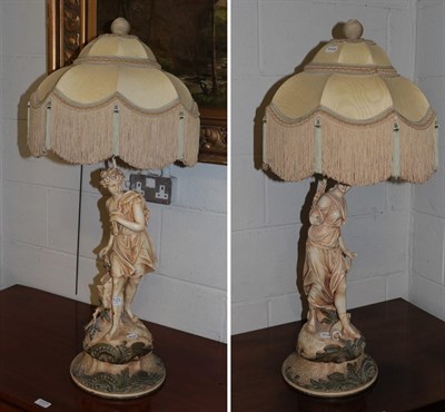 Lot 1123 - A pair of blush ivory figural table lamps