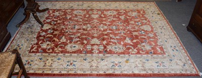 Lot 1135 - An Afgan Ziegler rug, the brick red field with all over design of flowers and vines enclosed by...