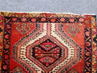 Lot 1137 - A Narrow Indian narrow runner, the brick red field of angular vines around a column of...