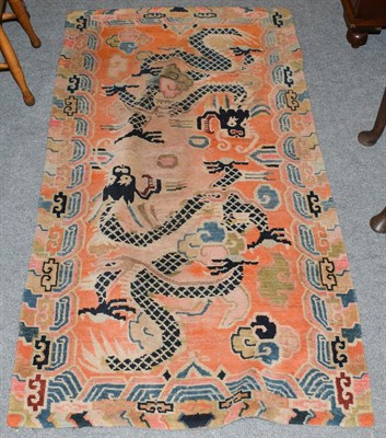 Lot 1138 - A Tibetan rug, the faded harlequin field with dragons enclosed by cloud borders, 160cm by 86cm