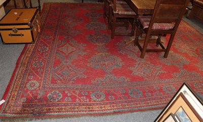 Lot 1150 - An Ushak carpet, the tomato red field of guls enclosed by plough head borders, 376cm by 364cm