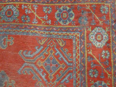 Lot 1150 - An Ushak carpet, the tomato red field of guls enclosed by plough head borders, 376cm by 364cm