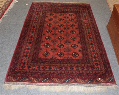 Lot 1152 - An Afghan Turkmen rug, the terracotta field of guls enclosed by multiple narrow borders, 195cm...