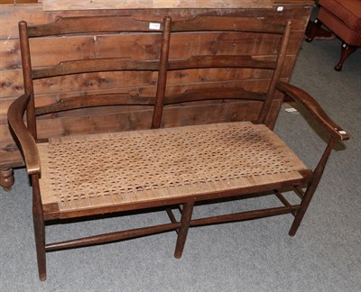 Lot 1197 - A rush-seated ladder-back bench, 120cm wide
