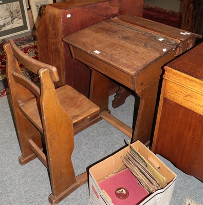 Lot 1204 - An early 20th century oak schoolroom desk, with slant front and integral seat