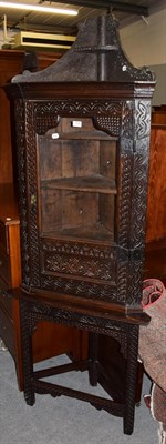 Lot 1310 - An 18th century carved oak glazed corner cupboard on stand, 67cm by 40cm by 207cm high