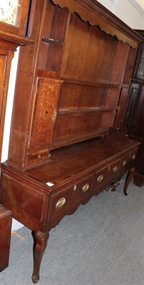 Lot 1340 - A late George III oak and mahogany crossbanded enclosed dresser, early 19th century, the dentil...