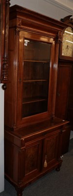 Lot 1341 - A 19th century walnut bookcase cabinet, the upper section with a glazed door, flanked by reeded...