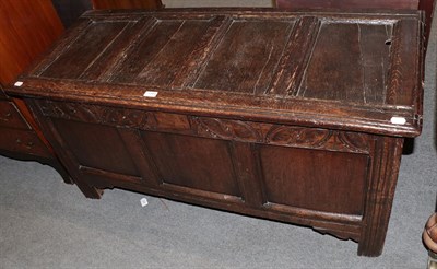 Lot 1344 - An early 18th century oak coffer, the four-panel top over a carved frieze above a...