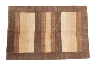 Lot 197 - Hand-knotted Modernist rug, the panelled field in a soft pallet enclosed by pale walnut...