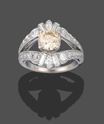 Lot 2211 - A Diamond Cluster Ring, the central fancy light brown round brilliant cut diamond in a white...