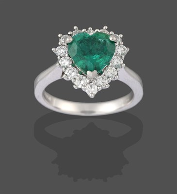 Lot 2223 - A Platinum Emerald and Diamond Cluster Ring, the heart shaped emerald within a border of round...