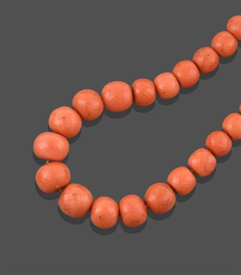 Lot 2225 - A Coral Bead Necklace, the thirty-nine graduated faceted coral beads terminate to a yellow...