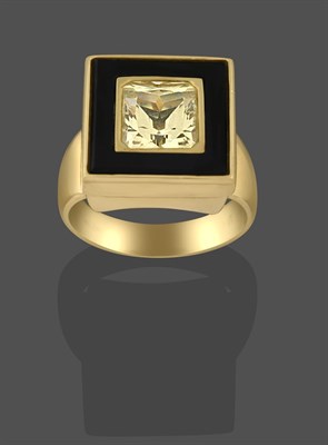 Lot 2239 - A Yellow Sapphire and Onyx Ring, the princess cut yellow sapphire to a square onyx border,  in...