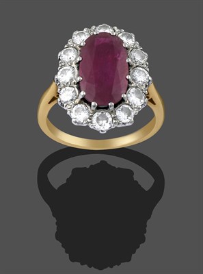 Lot 2291 - A Ruby and Diamond Cluster Ring, the central oval cut ruby within a border of round brilliant...