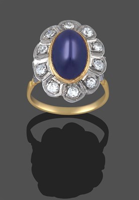 Lot 2296 - A Sapphire and Diamond Cluster Ring, the oval cabochon sapphire, in a yellow millegrain...