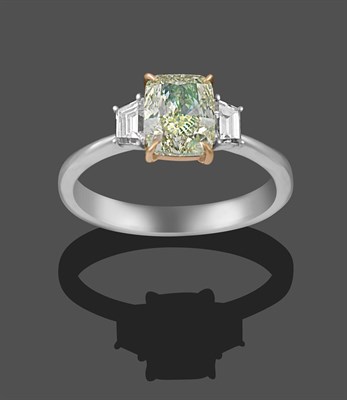 Lot 2310 - A Diamond Three Stone Ring, the central fancy light greenish-yellow cushion modified brilliant...