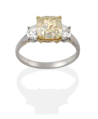 Lot 2333 - A Diamond Three Stone Ring, the central fancy light yellow modified square brilliant cut...