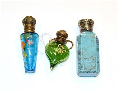 Lot 153 - Three metal mounted glass scent bottles, on tapering green glass, painted with foliage, another...